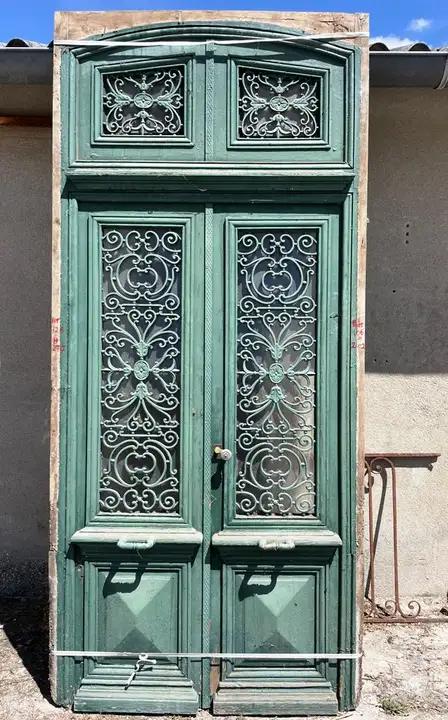 Ancienne porte d'entrée d'une maison Directoire. Porte á deux battants protégés par des grilles en fonte décorées. Ensemble comprenant : cadre, portes et impostes, serrure et poignées. Tés bon état. Dimensions du passage : Hauteur : 2.02m Largeur : 1.06m
