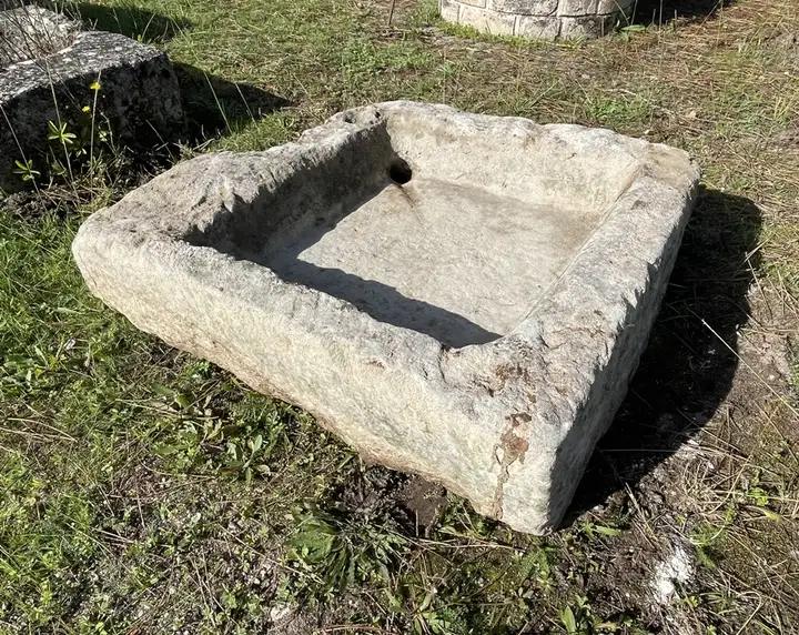 Ancien evier en pierre rustique avec évacuation percée à l'arrière