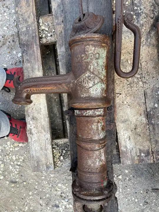 Ancienne pompe à bras en fonte décorée de perles