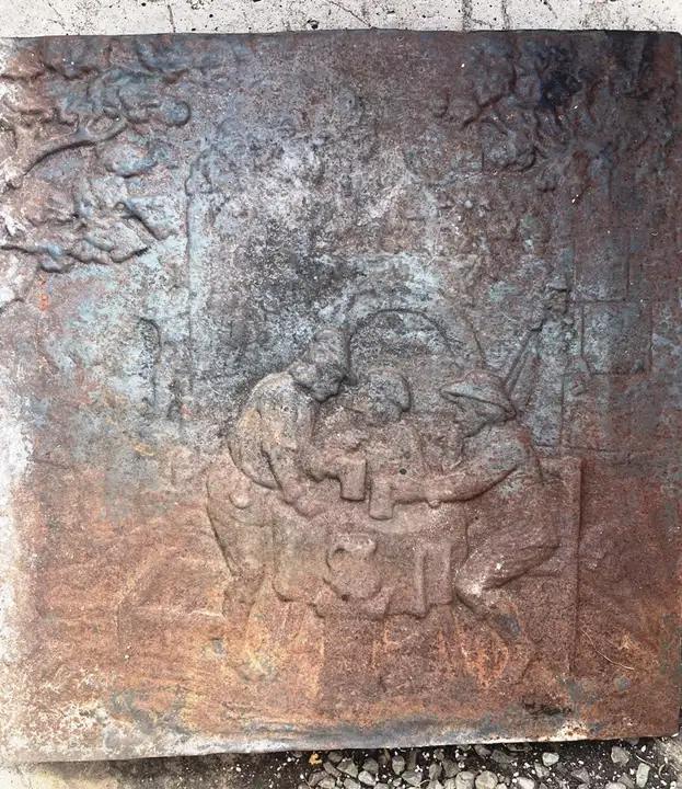 Plaque de fond de foyer en fonte décorée d'une scène populaire autour du feu