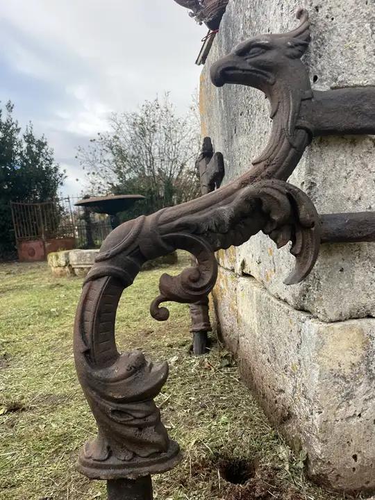 Paire de chasse-roues en fonte décorés de tete d'aigle au bec crochu et de rinceaux