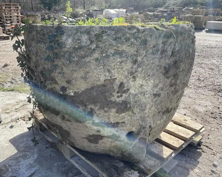 Ancienne ponne en pierre. Réceptacle servant á blanchir le linge. Bac en pierre de Charente de forme ovoide réemployé comme grosse jardinière