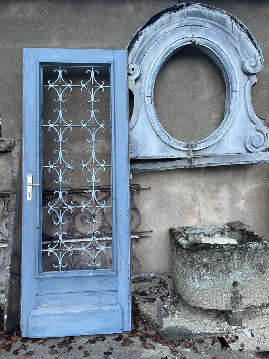 Porte d'entrée en bois exotique avec volet vitré intérieur et protection en fer forgé