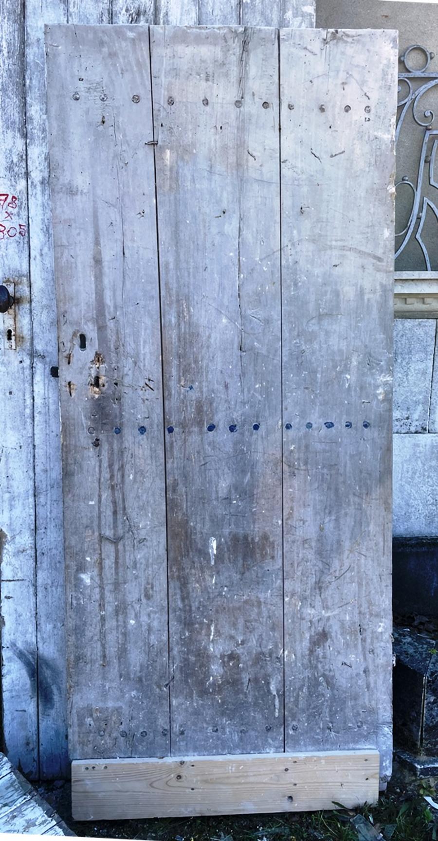 Ancienne porte de grenier en planches de peuplier encore férrée de ses charnières et clanche